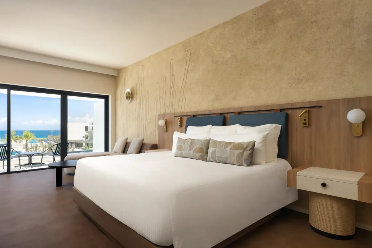 Junior Suite Ocean View with king-size bed and balcony overlooking the Caribbean at Secrets Baby Beach Aruba.