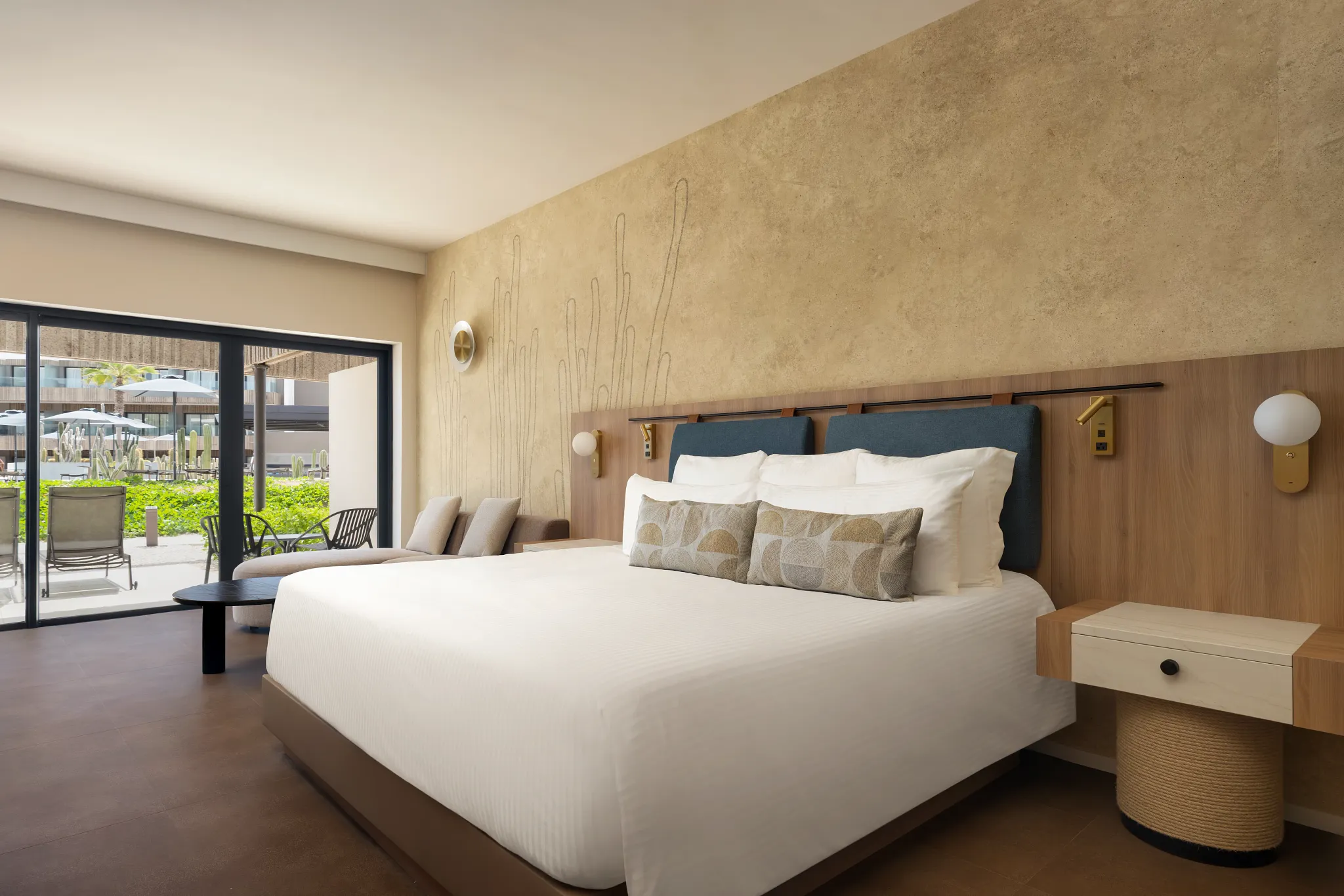 Junior Suite Poolside Terrace with king-size bed and sliding doors to private terrace at Secrets Baby Beach Aruba.