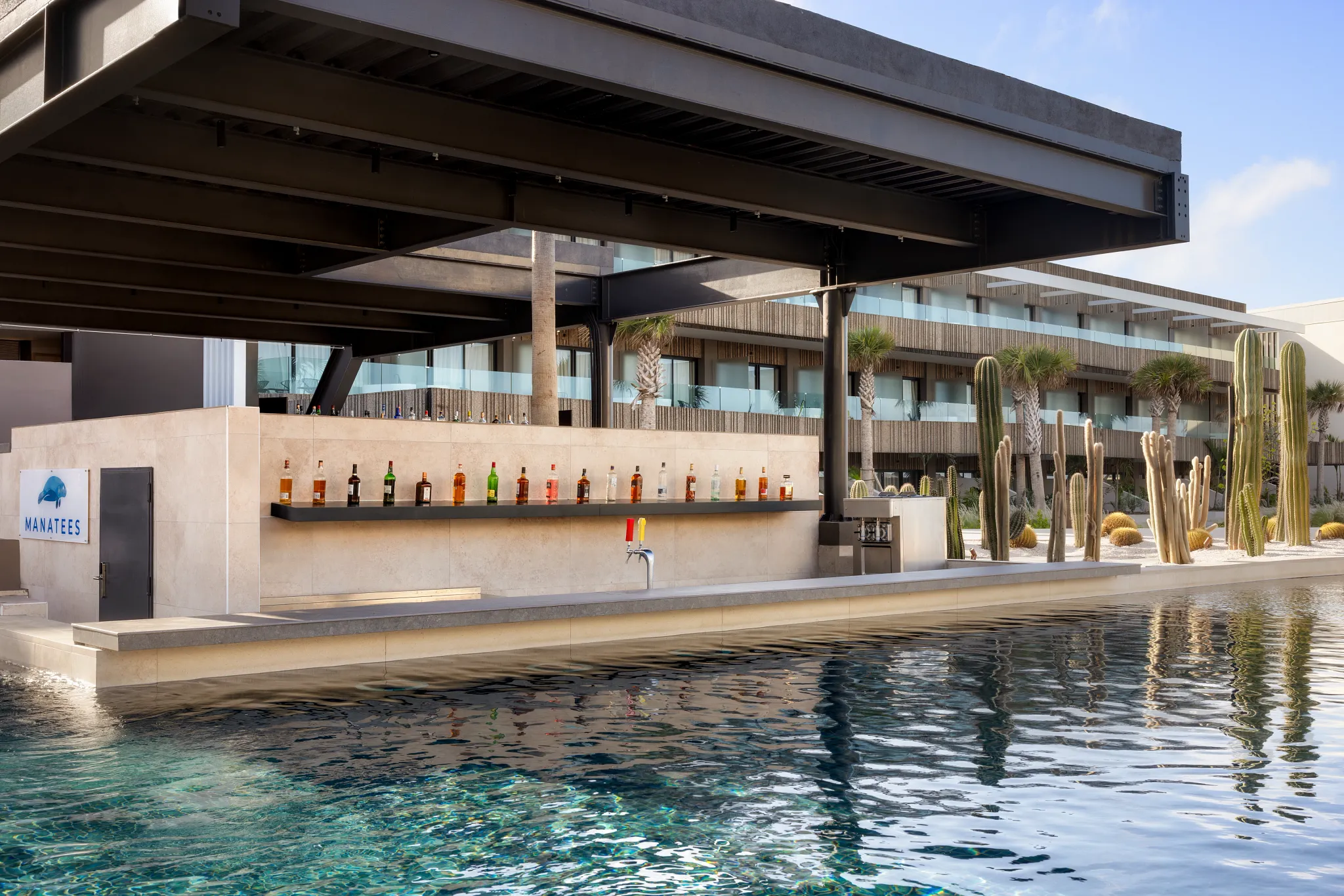 Manatees Swim-Up Bar at Secrets Baby Beach Aruba featuring an in-pool bar with tropical cocktails and modern poolside design.