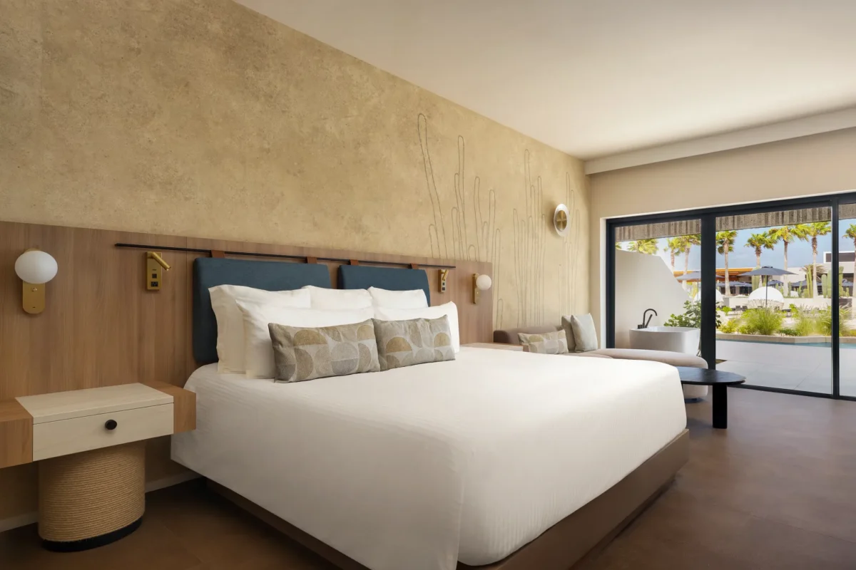 Preferred Club Junior Suite Swim Out with king-size bed and sliding doors to private terrace at Secrets Baby Beach Aruba.