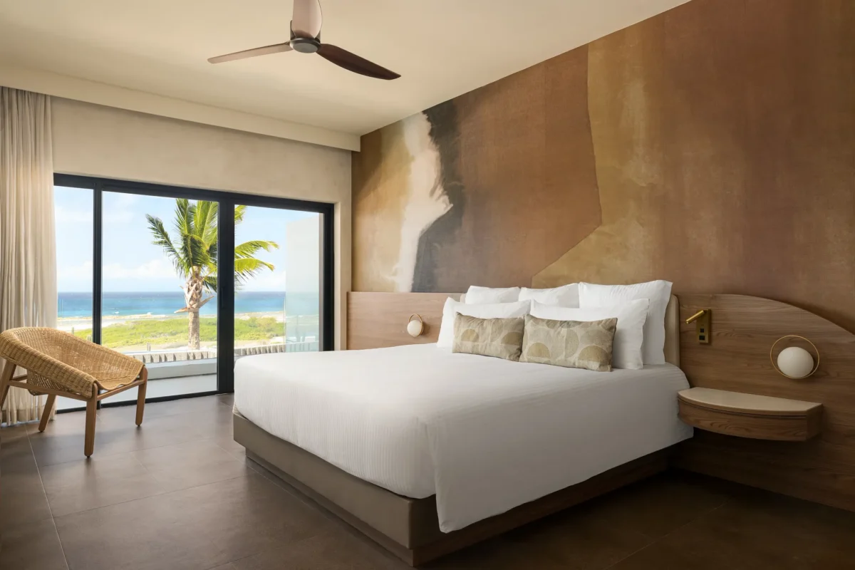 Preferred Club Master Suite Ocean View bedroom with king-size bed and balcony at Secrets Baby Beach Aruba.