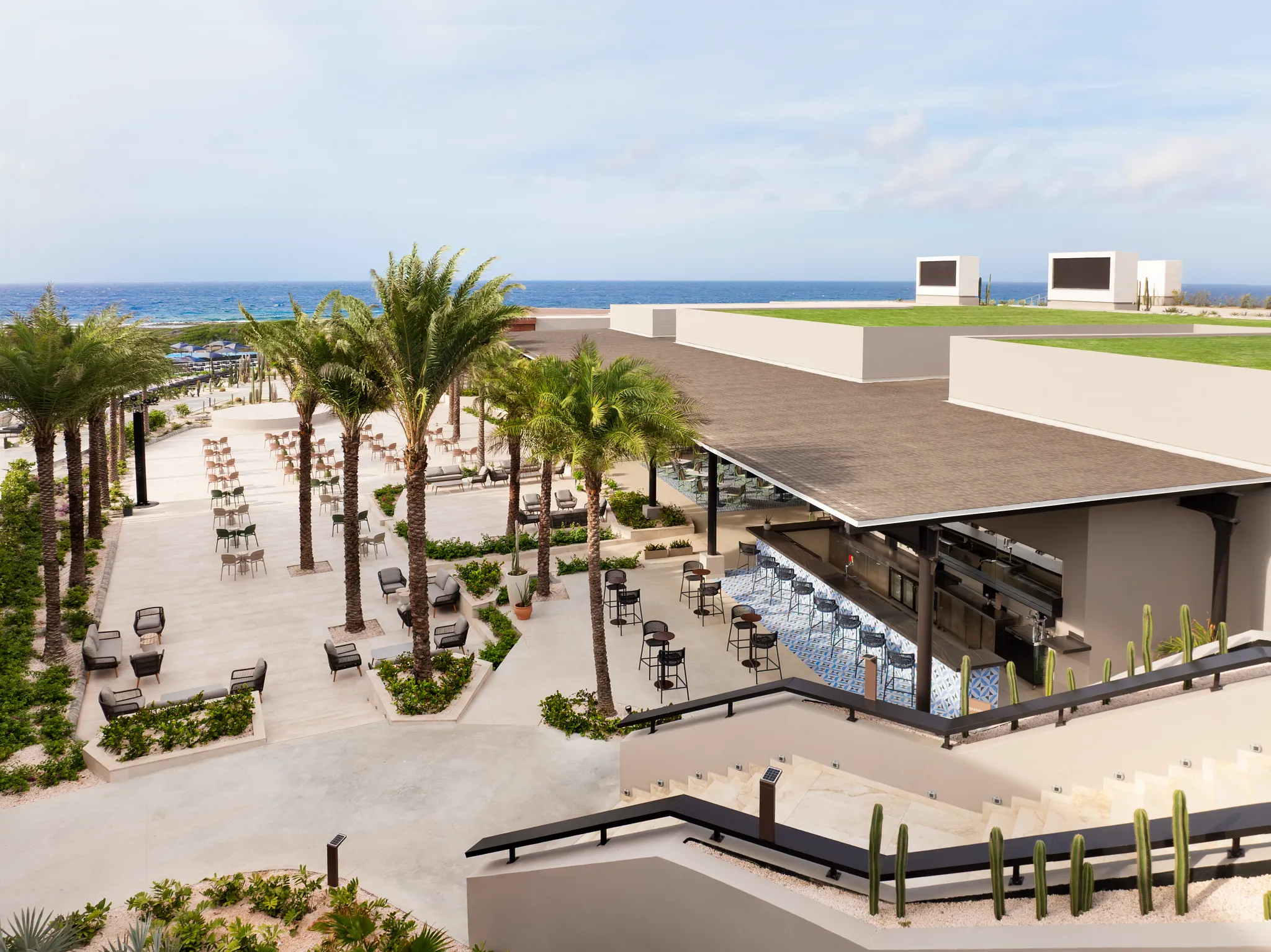 Outdoor terrace and bar area with ocean views at Secrets Baby Beach Aruba.