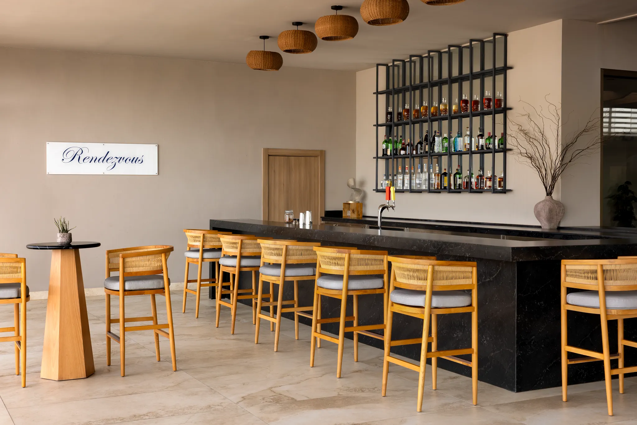 Rendezvous Lobby Bar at Secrets Baby Beach Aruba featuring elegant bar seating, premium spirits display, and relaxed lounge atmosphere.