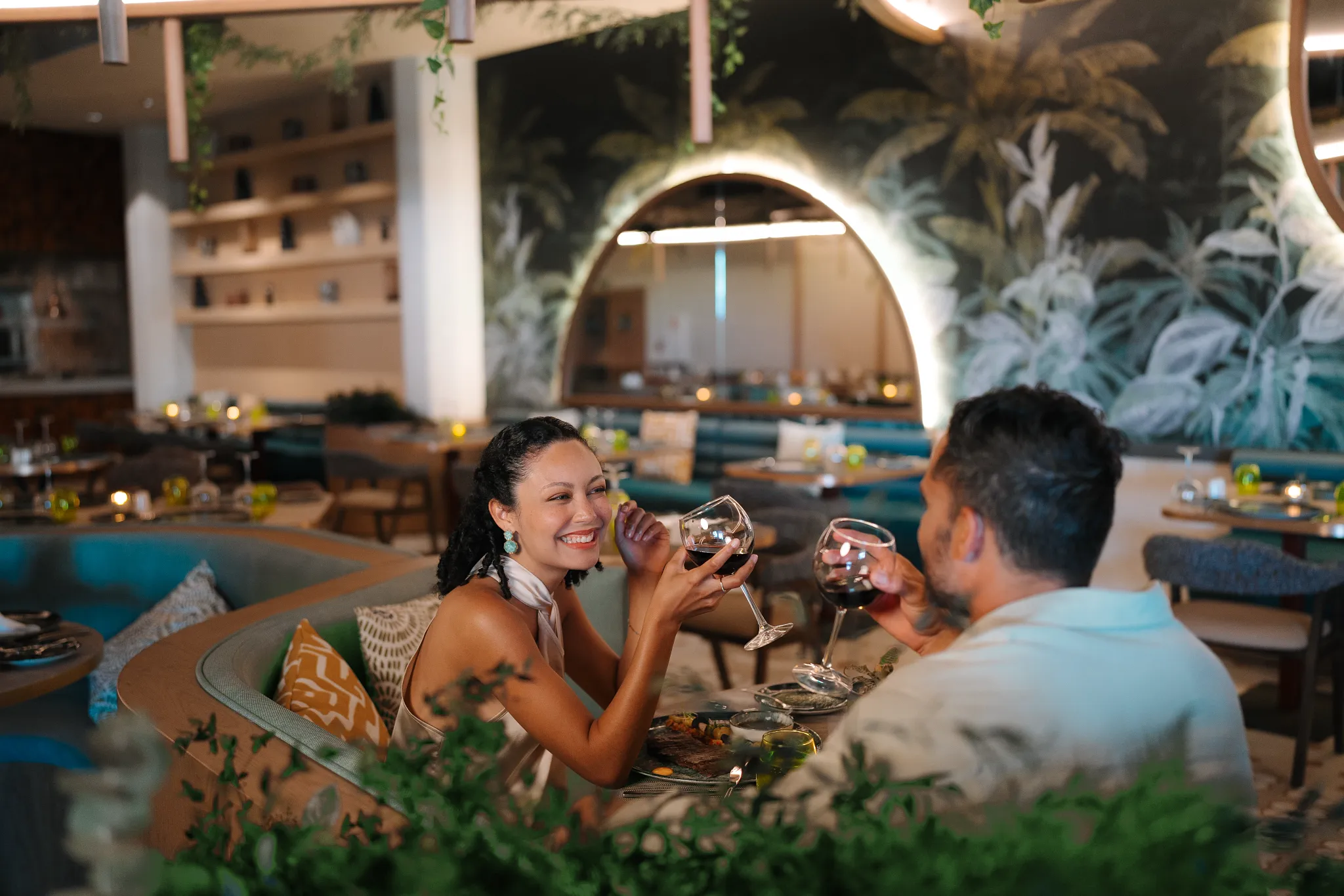 Couple toasting wine glasses during a romantic dinner at Secrets Baby Beach Aruba.